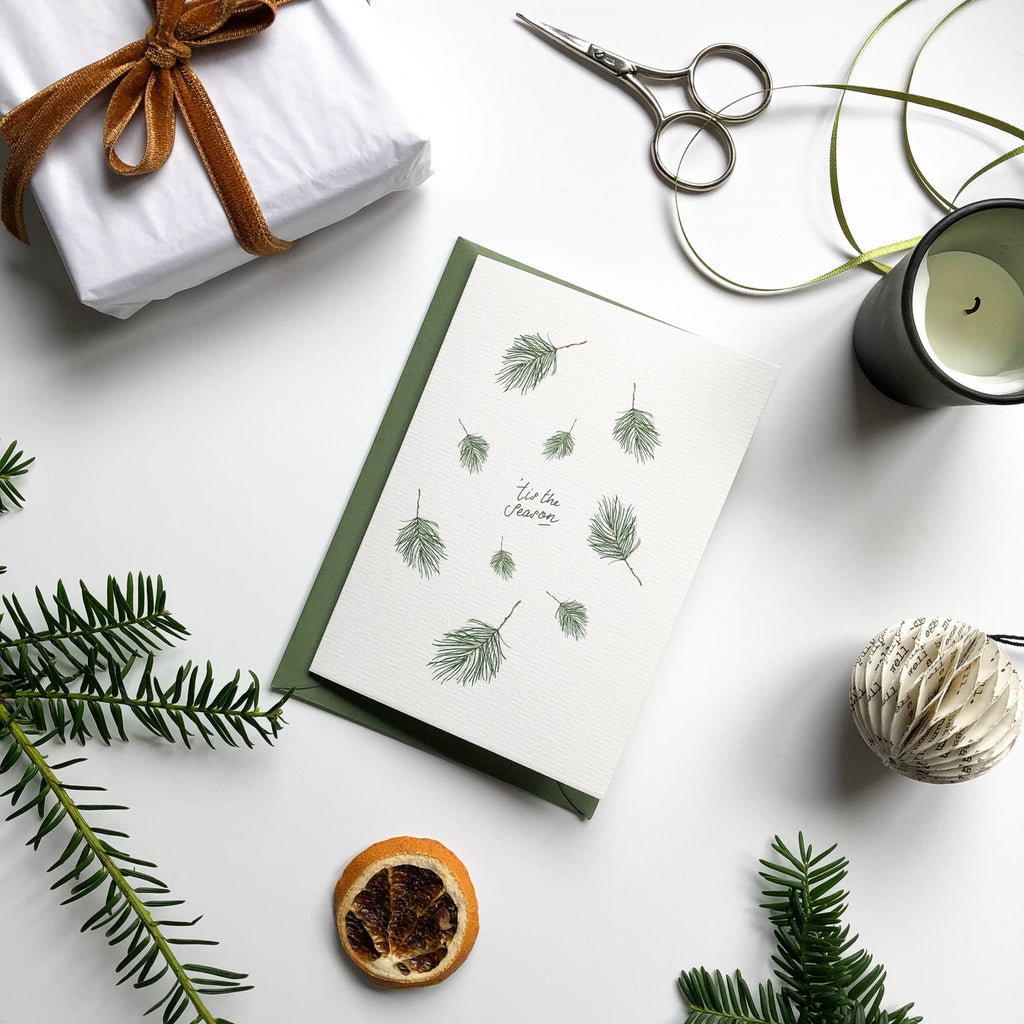 falling pine christmas card with green envelope in christmas scene