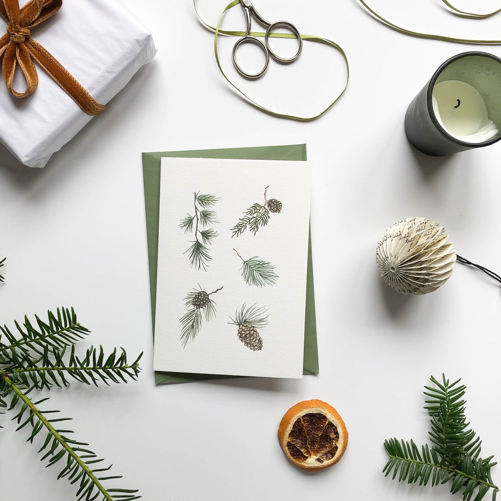 christmas card with hand illustrated winter pine foliage & green envelope